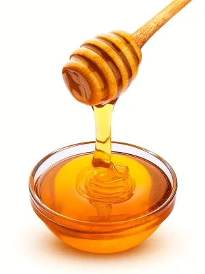 Honiglöffel mit Honig über Glasschale – Nahaufnahme